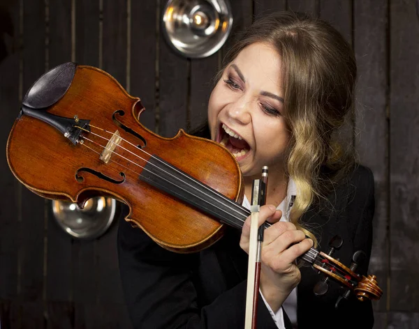 暗い背景で少女がバイオリンを噛んだ 若いヴァイオリニストの肖像 — ストック写真