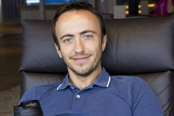 Portrait of an attractive man in a blue t-shirt. A young man is resting.