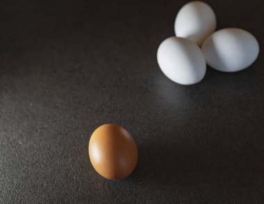 Siyah arka planda beyaz yumurta ve kahverengi yumurta. Masadaki yumurtalar. 