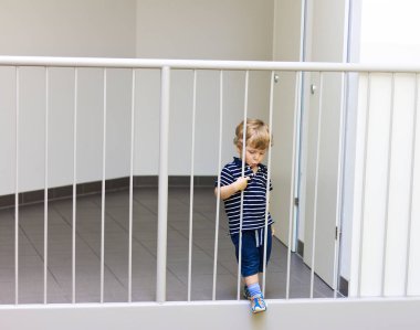 Küçük çocuk apartman kapısının yanında. Hild ailesini bekliyor..