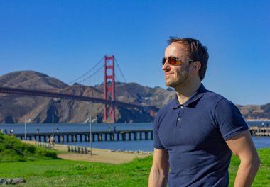 Golden Gate Köprüsü 'nün oradaki San Francisco' da genç bir adam. Altın kapı köprüsü. Kaliforniya 'ya seyahat.