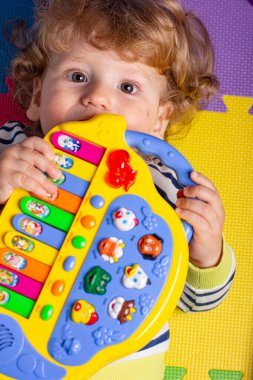 Küçük çocuk evde oyuncaklarla oynuyor..