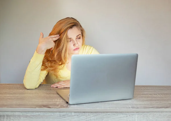Woman tired of online work.Problem with laptop.Girl with a laptop sits at a table