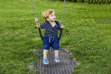 Salıncakta sallanan küçük çocuk. Dışarıdaki sevimli çocuk.. 