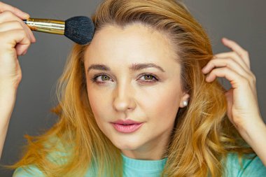 Güzellik blogcusu makyajı test ediyor. Genç bir kız makyaj öneriyor. Güzel bir kadın yüz pudrası sürüyor. Genç bir kız yüz pudrasını test ediyor..