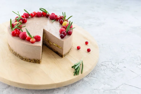 Ahşap bir tahtada ahududu ve biberiyeyle süslenmiş çiğ çikolatalı pasta. Glütensiz, vejetaryen yemeği..