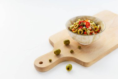 Muffuletta için beyaz bir masada bir kasede zeytin salatası. Yatay yönelim, boşluğu kopyala.