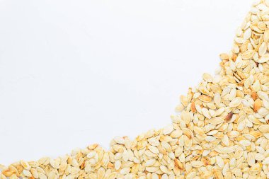 Beyaz arka planda balkabağı tohumları. Yatay yönelim, boşluğu kopyala.