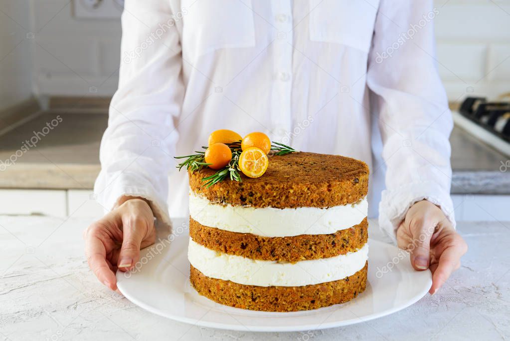 Girl with carrot cake decorated with kumquat and rosemary.