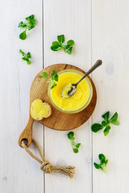 Otlu Ghee yağı ve tahta bir tahtanın üzerinde bir dilim ekmek. Dikey yönelim, üst görünüm.