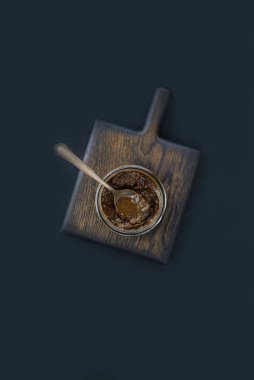 Tahta bir tahtanın üstündeki kavanozda keten macunu var. Dikey yönelim, üst görünüm.