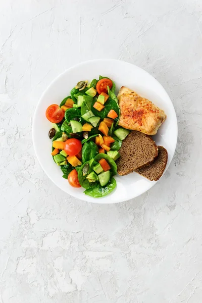 Kilo Takipçileri diyeti: sebze salatası, hindi filetosu, glütensiz ekmek. Dikey yönelim, üst görünüm.