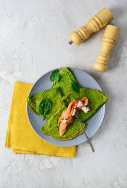 Gri tabakta somon ve peynirli ıspanaklı krep. Sağlıklı gıda konsepti, glütensiz..