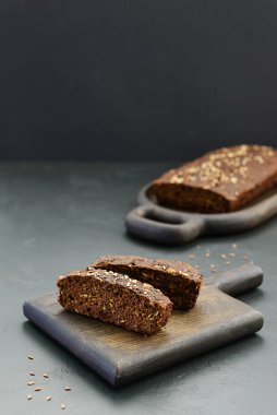 Koyu tahta üzerinde ev yapımı keten tohumu ekmeği dilimleri. Sağlıklı yemek, glütensiz, şekersiz, laktozsuz.