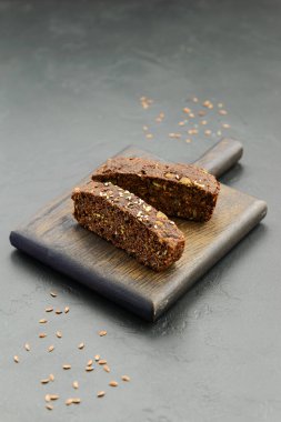 Koyu tahta üzerinde chia tohumlu ev yapımı keten tohumu ekmeği dilimleri. Sağlıklı yemek, glütensiz, şekersiz, laktozsuz.