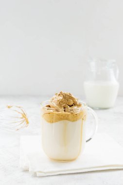 Beyaz peçetede sütlü Dalgona kahvesi.