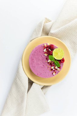 Hafif havluyla ahududu ve limonlu kaju keki. Dikey oryantasyon, üst görünüm. Çiğ tatlı, şekersiz, glütensiz, laktozsuz..