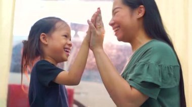 Sevgi dolu bir aile. Anne ve kızı beşlik çakıp sarılıyorlar.