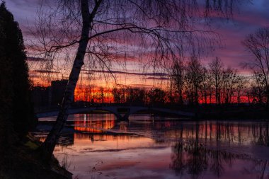 Gölün üzerindeki görkemli günbatımı. Renkli doymuş bulutlar suya yansıyor. Dramatik sahne. Güzel manzara. Doğadaki renk. Dünyadaki güzellik.
