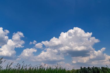 Bulutlar mavi gökyüzünde güneş ışınlarıyla