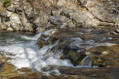 Bir şelalenin kayalarından akan dalgalı sular.