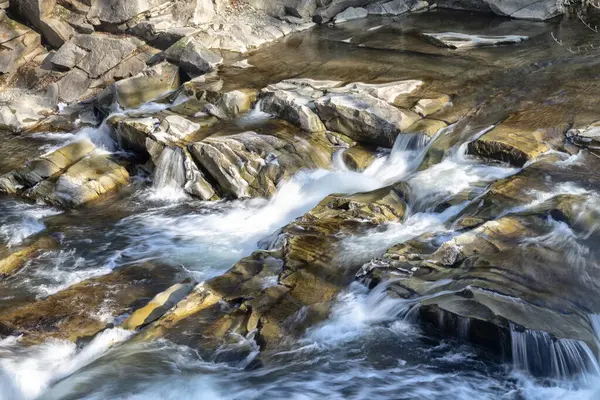 Rapid waters splicing through the rocks of a waterfall