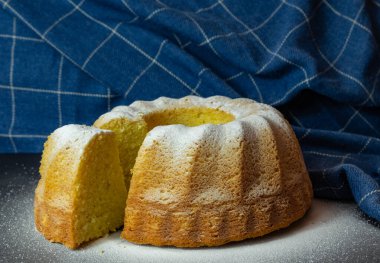 limonlu kek mavi arka planda pudra ile pişirilmiş