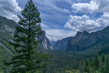Yosemite Ulusal Parkı 'nda şelale güneşli havada mavi gökyüzünde bulutlu