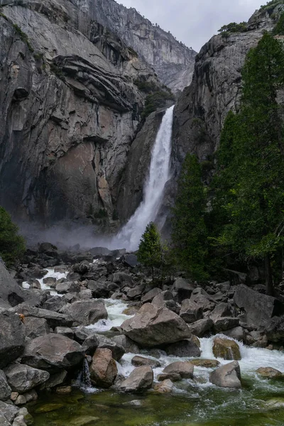 Yosemite Ulusal Parkı 'nda şelale güneşli havada mavi gökyüzünde bulutlu
