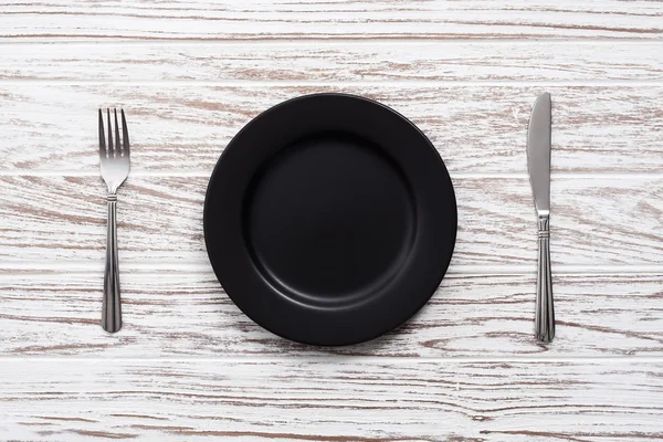 Piatto vuoto forchetta coltello argenteria bianco tavolo di legno sfondo — Foto Stock