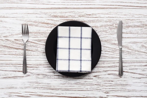 Plato vacío servilleta tenedor cuchillo plata fondo de mesa de madera blanca —  Fotos de Stock