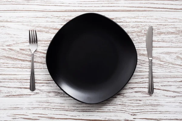 Cuchillo de tenedor plato vacío plata fondo de mesa de madera blanca — Foto de Stock