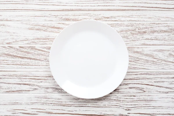 Leere Platte auf weißem Holztischhintergrund flach gelegt — Stockfoto