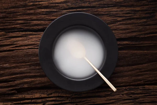 Cuchara cuenco vacío negro sobre fondo de mesa de madera —  Fotos de Stock