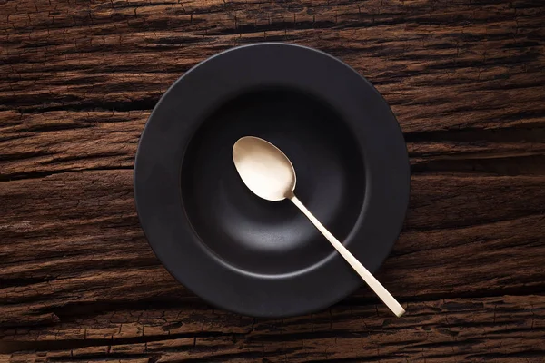 Cuillère bol vide noir sur fond de table en bois — Photo