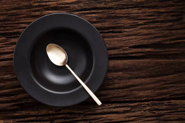 Cucchiaio ciotola vuota nero su sfondo tavolo di legno — Foto Stock