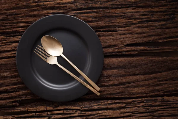 Cuillère à fourchette vide noire sur fond de table en bois — Photo