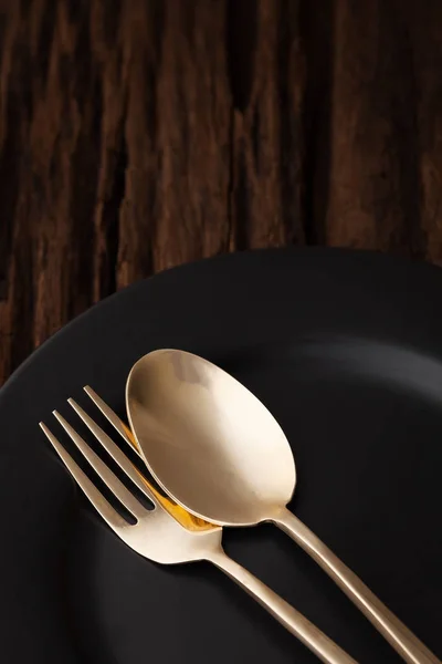 Cuchara de tenedor de plato vacío negro sobre fondo de mesa de madera — Foto de Stock