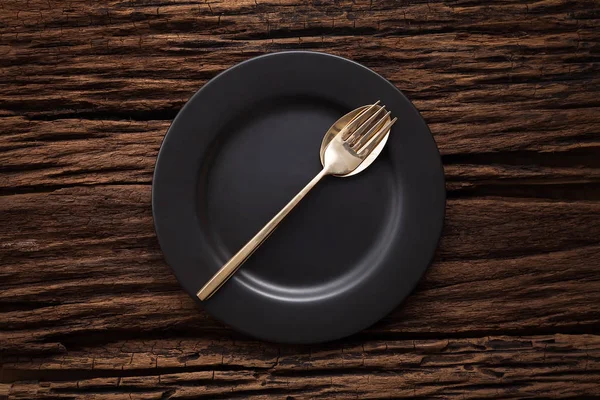 Cuillère à fourchette vide noire sur fond de table en bois — Photo