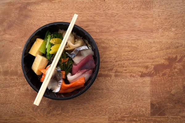 Japanese food Tekka Don take away on wooden background — Stock Photo, Image