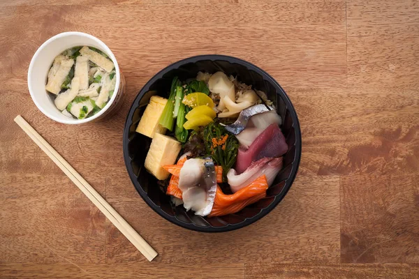 Japanese food Tekka Don take away on wooden background — Stock Photo, Image