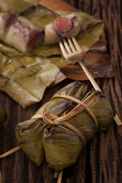 Khao Tom Mat - Postre tailandés - Arroz pegajoso, plátano y frijoles negros envueltos en hojas de plátano — Foto de Stock