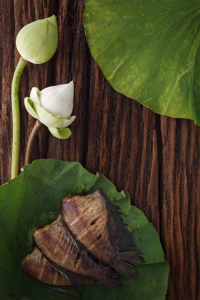 Thai food dried salted damsel fish fried with flower lotus jasmine decoration on wooden background beautiful flat lay still life rustic asia — Stock Photo, Image