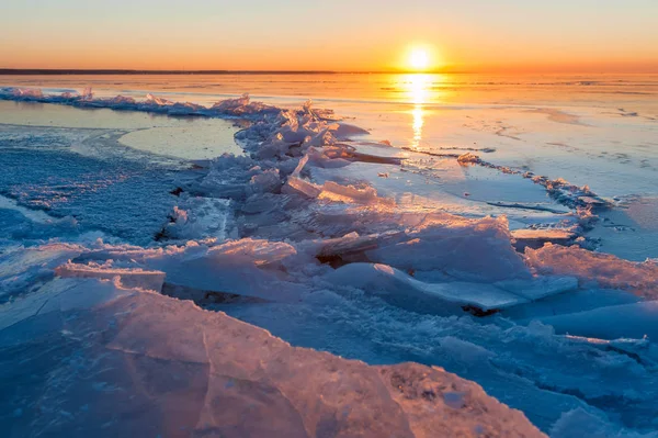 Riss im Eis auf einem zugefrorenen See bei Sonnenuntergang — Stockfoto