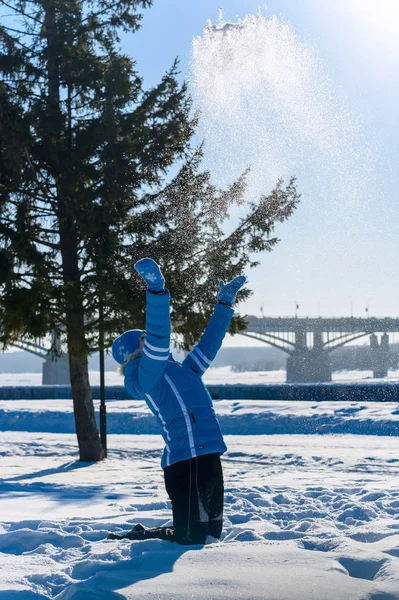 Retrato ao ar livre da jovem menina feliz. Ele joga a neve no parque de inverno — Fotografia de Stock