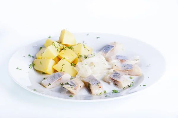 Haşlanmış patates, soğan ve beyaz bir arka plan üzerinde otlar ile ringa balığı — Stok fotoğraf