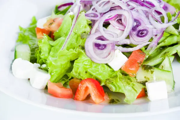 Gemüsesalat mit Tomaten, Gurken, Feta-Käse, Zwiebeln und Tomaten auf weißem Hintergrund — Stockfoto