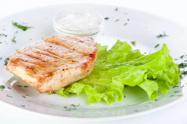 Turkey steak with lettuce and sauce on a white background — Stock Photo, Image