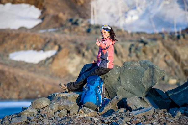 Mujer joven feliz con una mochila sonríe en el lago —  Fotos de Stock