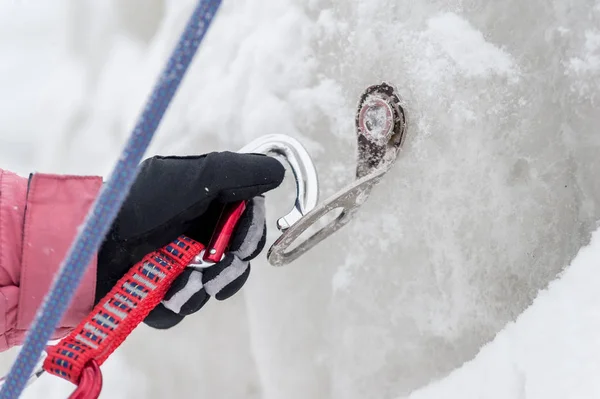 Kletternde Sportlerhände lösen das Seil im Karabiner. Verschraubung von Eisankern — Stockfoto